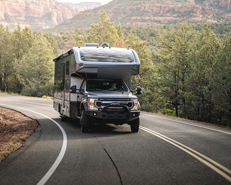Super C motorhome driving through scenic mountain highway